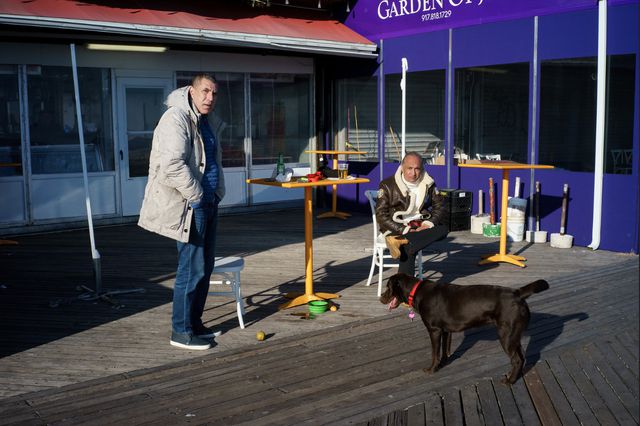 A photo of Men and dog at a bar on the Brighton Beach boardwalk